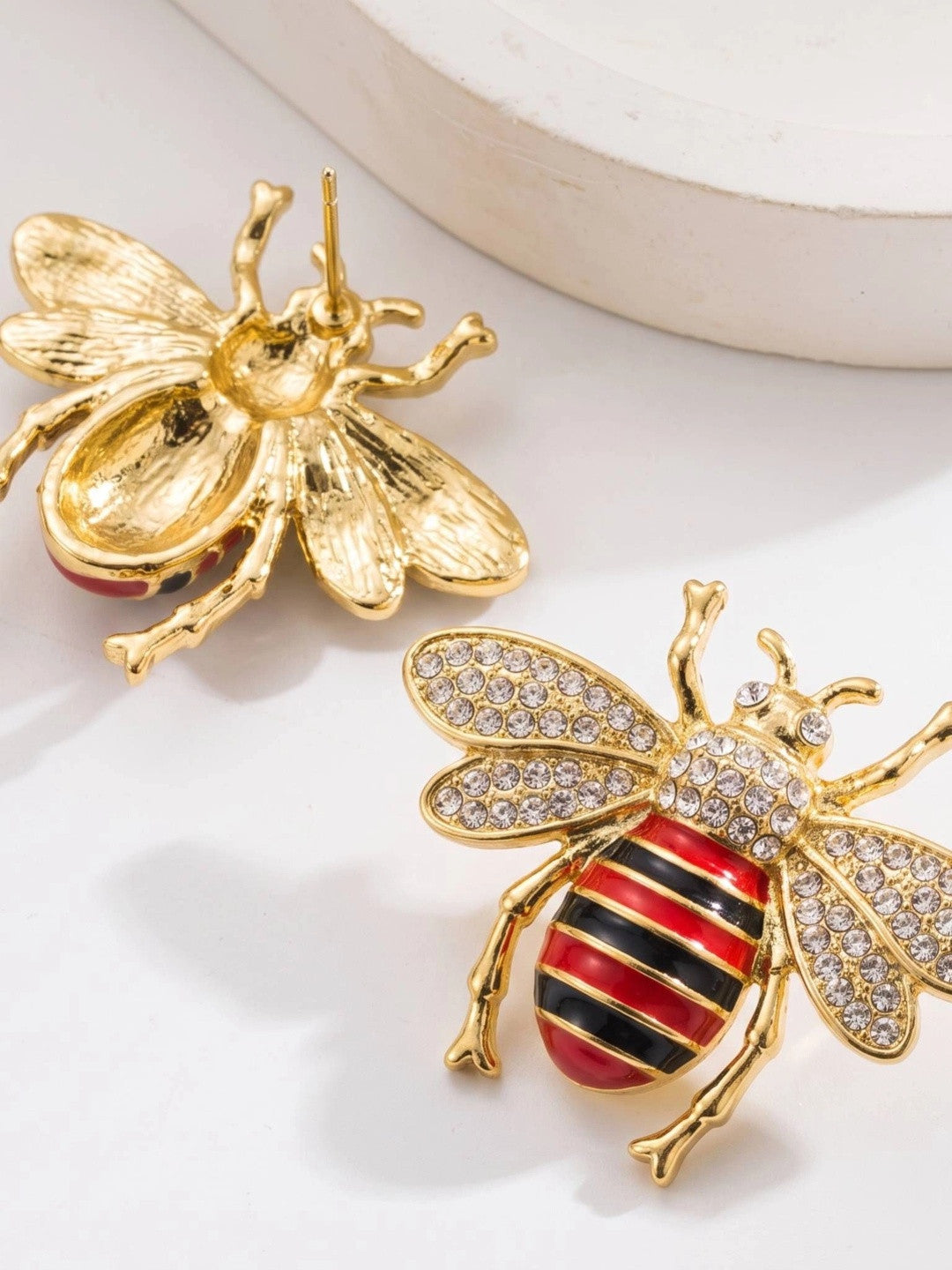 Front and back view of bee stud earring showing crystal-set wings and gold textured reverse with stud post