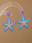 Pair of raffia woven starfish drop earrings in purple, turquoise and pink displayed on a clear acrylic stand against a warm beige background