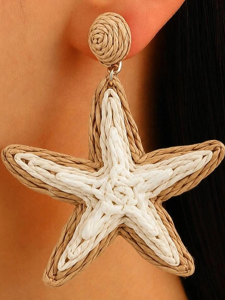 Close-up of woven rattan starfish drop earring worn on a model's ear showing beige and white cord detail