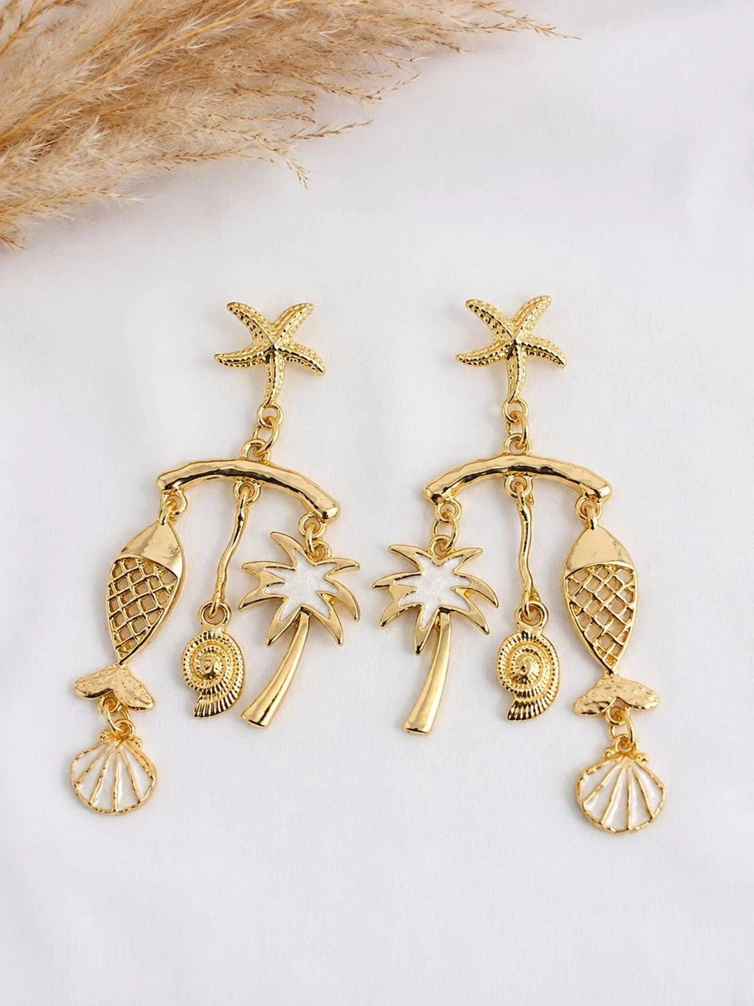 Both gold-plated ocean charm earrings laid flat on white surface showing starfish top, curved bar and three hanging charms