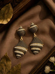 Pair of oxidised gold geometric drop earrings with white crystal bands on brown silk fabric