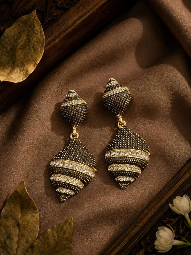 Pair of oxidised gold geometric drop earrings with white crystal bands on brown silk fabric