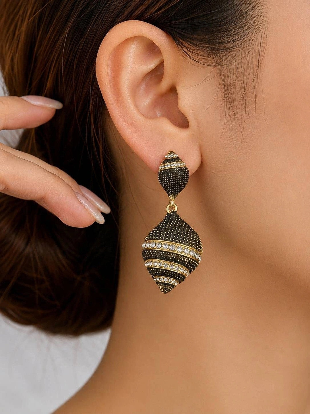 Single oxidised gold crystal drop earring worn on a woman's ear showing full length