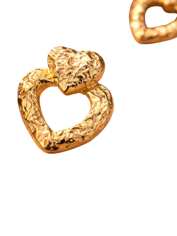 Two gold-toned hammered double heart drop earrings photographed against a clean white background