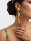 Woman wearing a gold kundan chandbali ear-cuff earring with long pearl drop against a white background