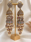 Pair of long oxidised gold elephant jhumka earrings displayed on a gold jewellery stand showing front view with pearl drops and pastel stones