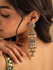 Indian woman wearing one oxidised gold elephant jhumka earring showing scale and drape against her neck with a festive outfit