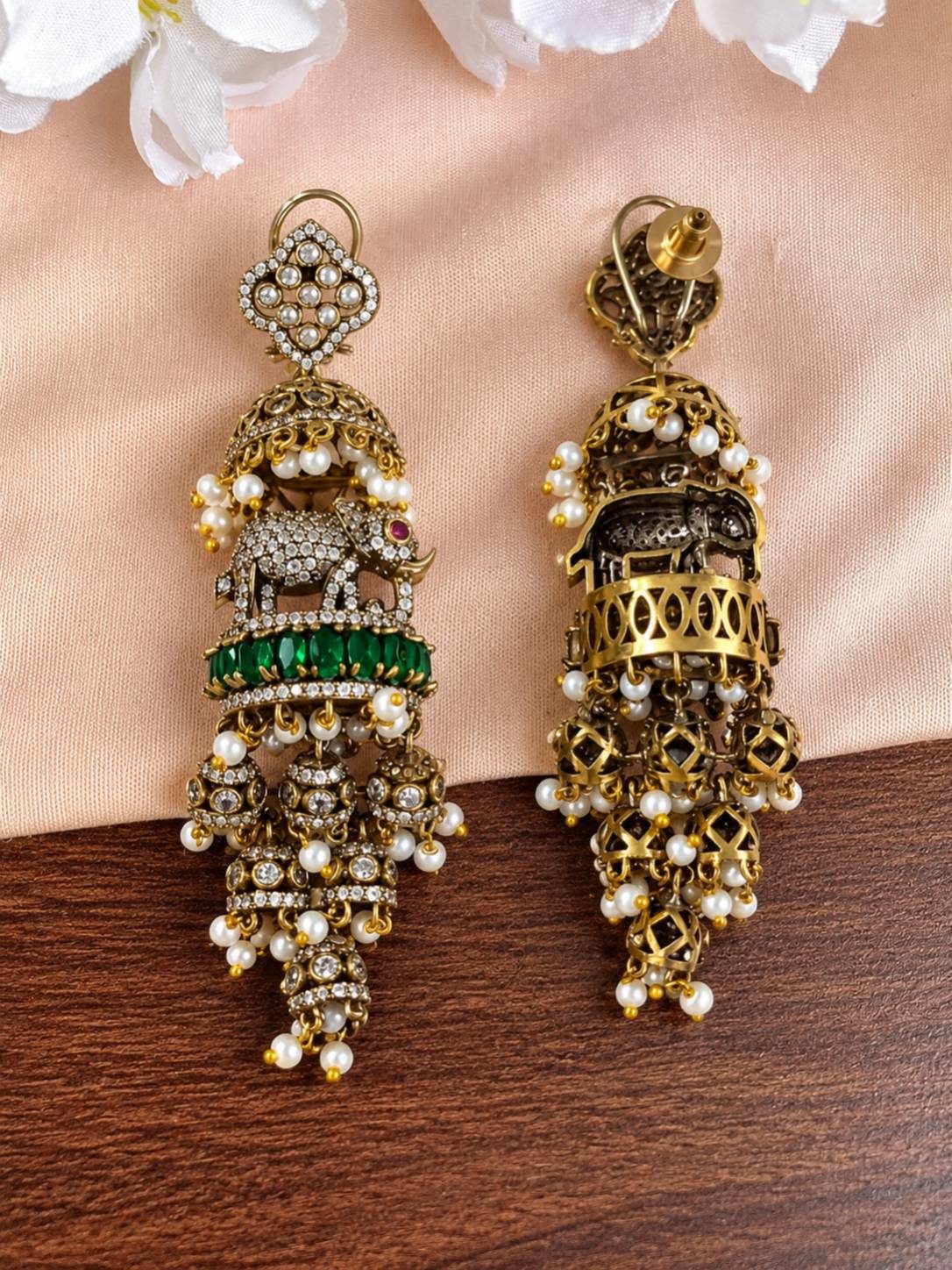 Side-by-side front and back view of one elephant jhumka earring on blush fabric, revealing gold filigree reverse and push-back stud fitting