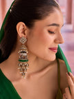 Woman wearing a single antique gold elephant jhumka earring with green dupatta draped over shoulder, showing scale and drape of the earring