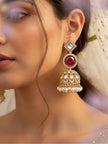 Woman wearing gold-plated kundan jhumka earring with ruby-red centre stone and pearl fringe drops