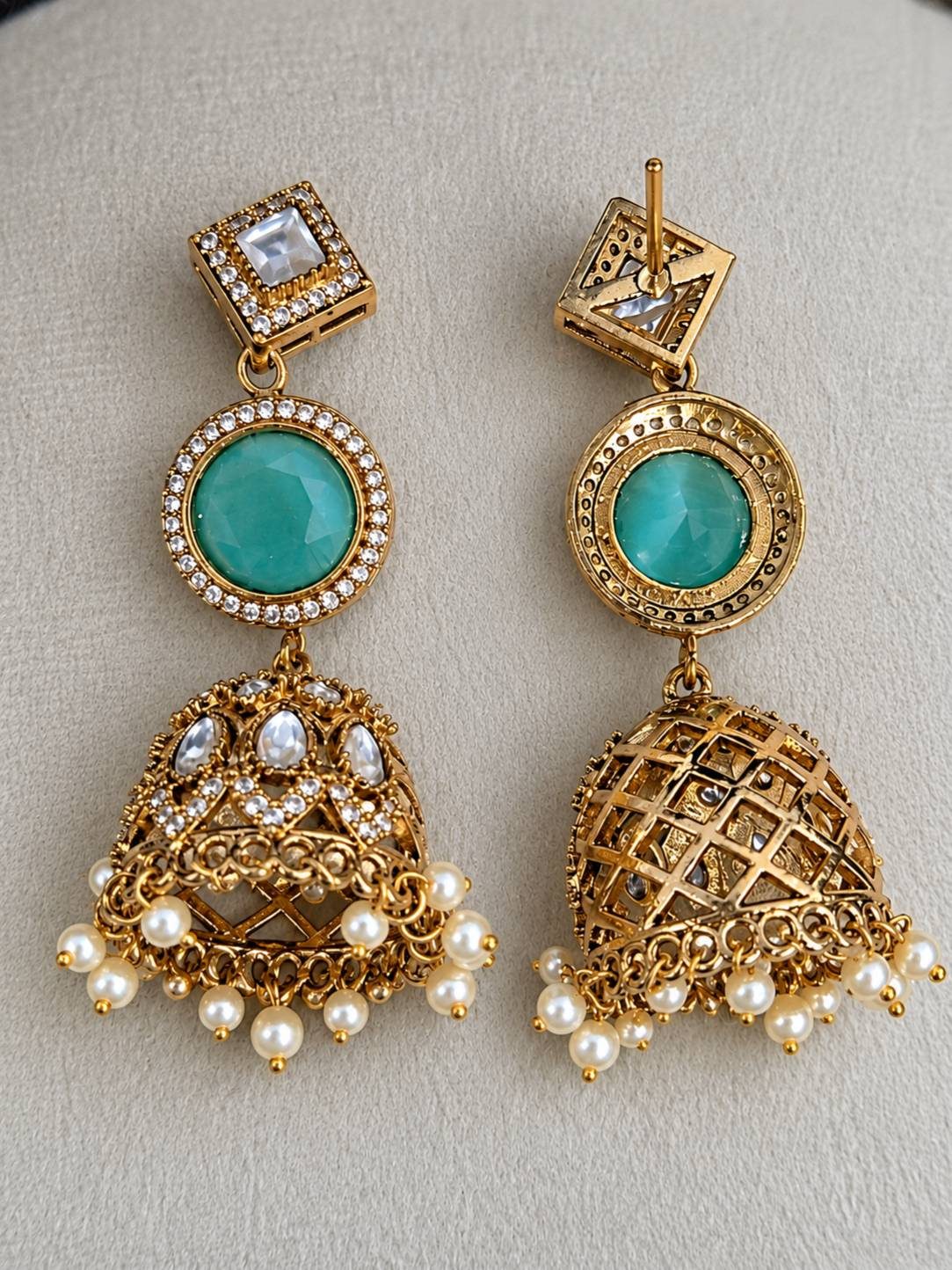 Front and back view of gold-plated kundan jhumka earring pair showing turquoise centre stone and pearl fringe