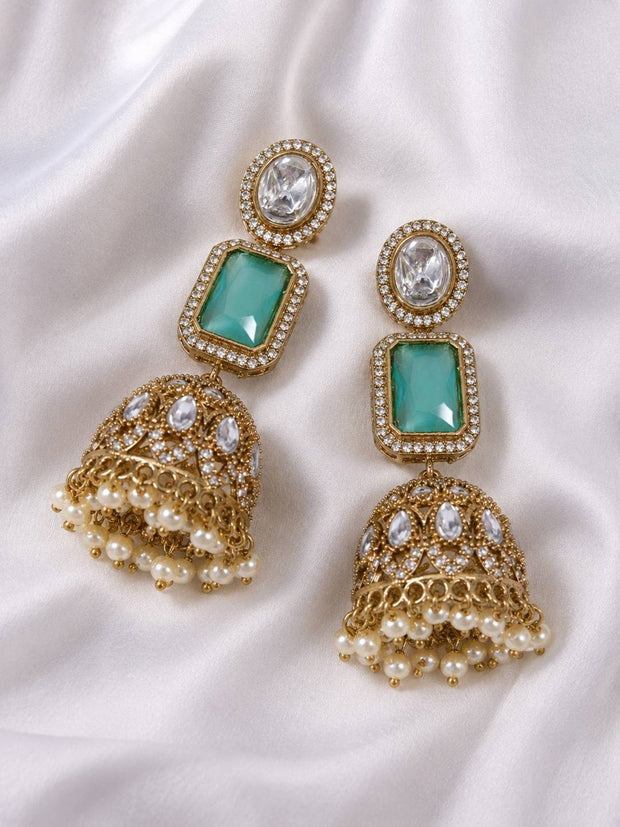 Pair of gold-plated kundan jhumka earrings with mint green stone and pearl drop fringe on white silk