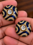 Close-up of two blue enamel kundan dome studs held in hand showing zirconia pave detail and polki-style centre stone