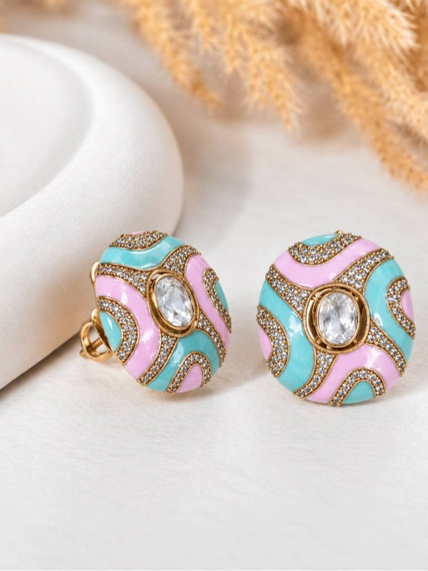 Pair of pastel mint and pink enamel dome stud earrings with pavé crystal borders and oval centre stone, shown at an angle on a white surface