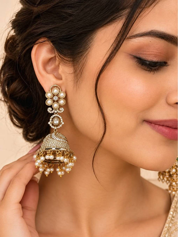 Woman wearing a gold-plated pearl jhumka earring with crystal dome and pearl drop fringe, hair in updo