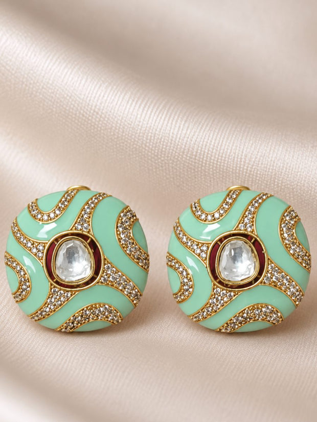 Pair of round mint green enamel kundan stud earrings on cream satin fabric
