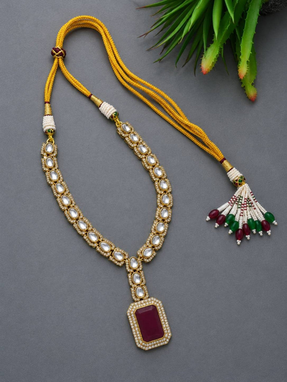 Kundan ruby pendant necklace laid flat showing yellow dori closure and multicolour beaded tassel end