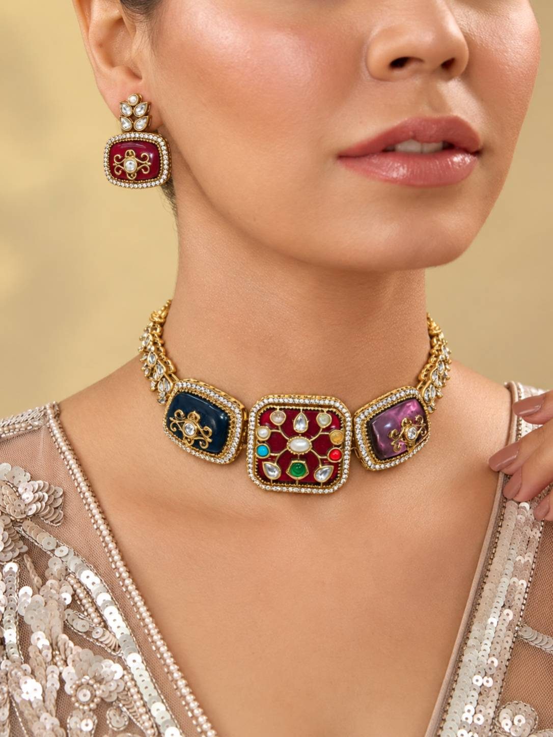 Model wearing gold-plated kundan navratan choker necklace and maroon enamel stud earring styled with a beige sequin outfit