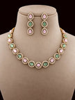 Gold-plated choker necklace and drop earrings with pink and green cabochon stones displayed on a beige jewellery bust