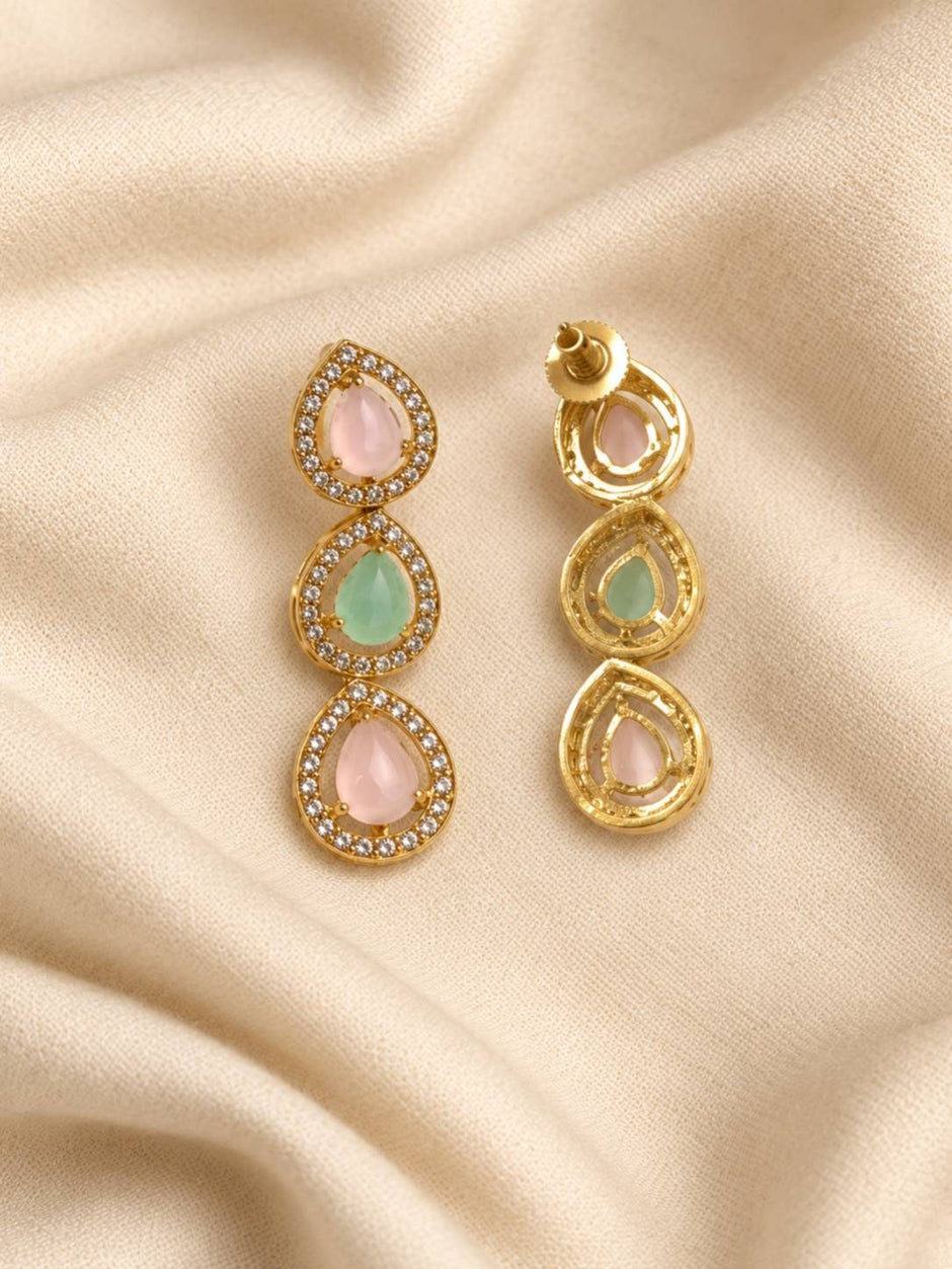 Close-up of three-tier teardrop drop earrings with pink and green cabochon stones in gold zirconia halo settings, front and back view