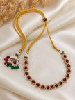 Long gold-plated ruby CZ teardrop necklace with golden silk thread adjustable cord and decorative beaded tassel, laid flat on ivory fabric