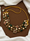 Flat lay of three-strand Kundan pearl necklace showing adjustable gold dori closure and decorative tassel detail on brown background