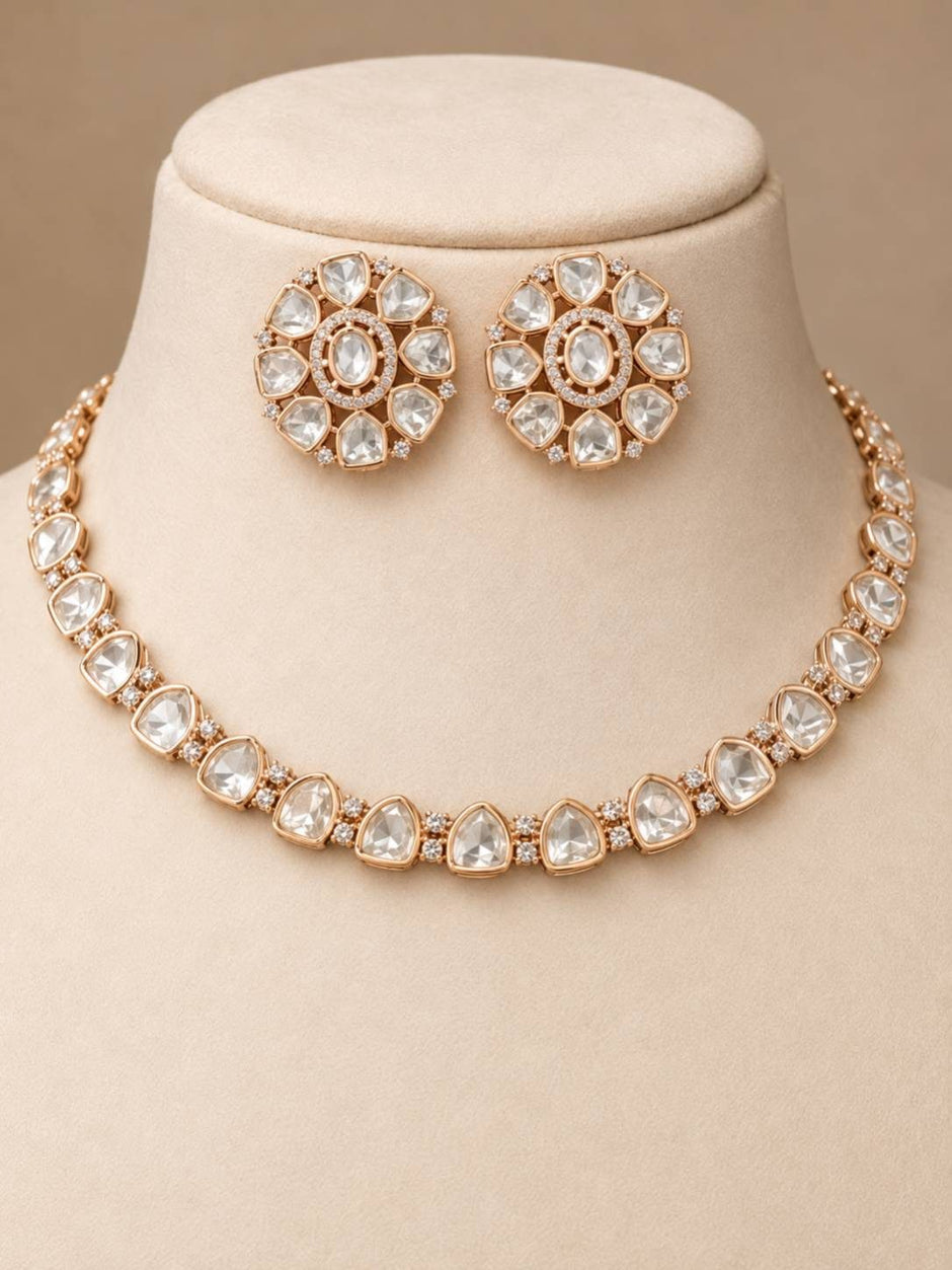 Rose gold polki choker necklace and floral stud earring set displayed on a beige jewellery bust
