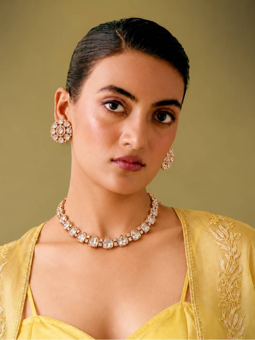Woman wearing rose gold polki choker necklace and matching stud earrings with a yellow embroidered outfit