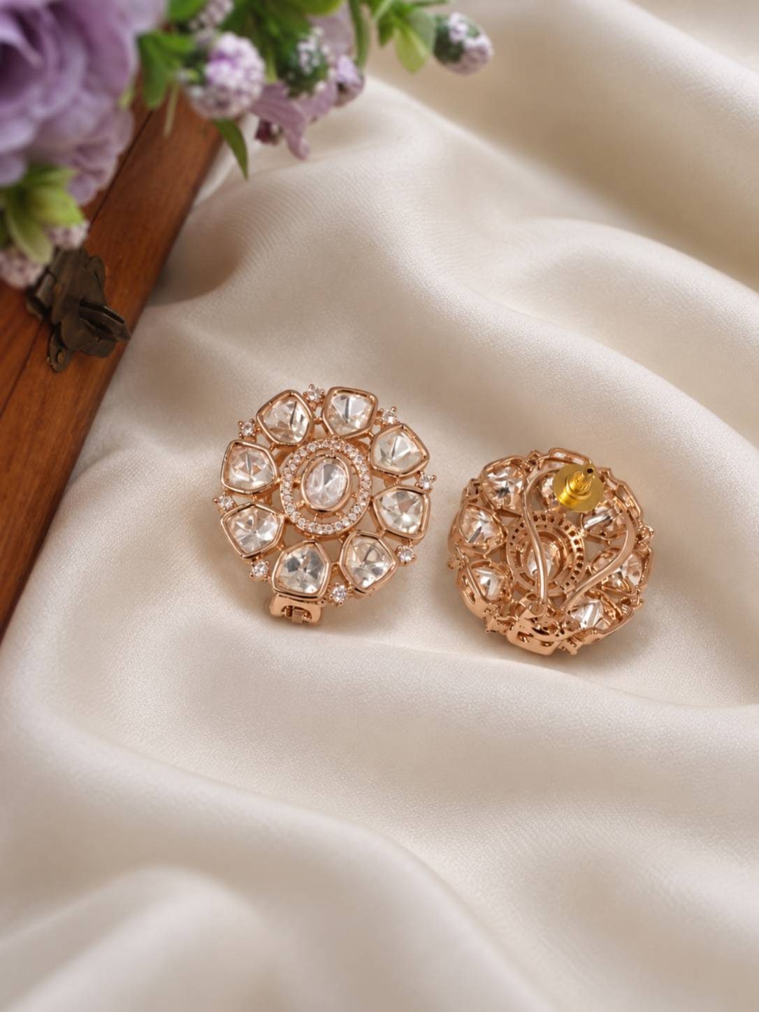 Front and back view of rose gold floral polki stud earrings on ivory silk fabric showing push-back fitting