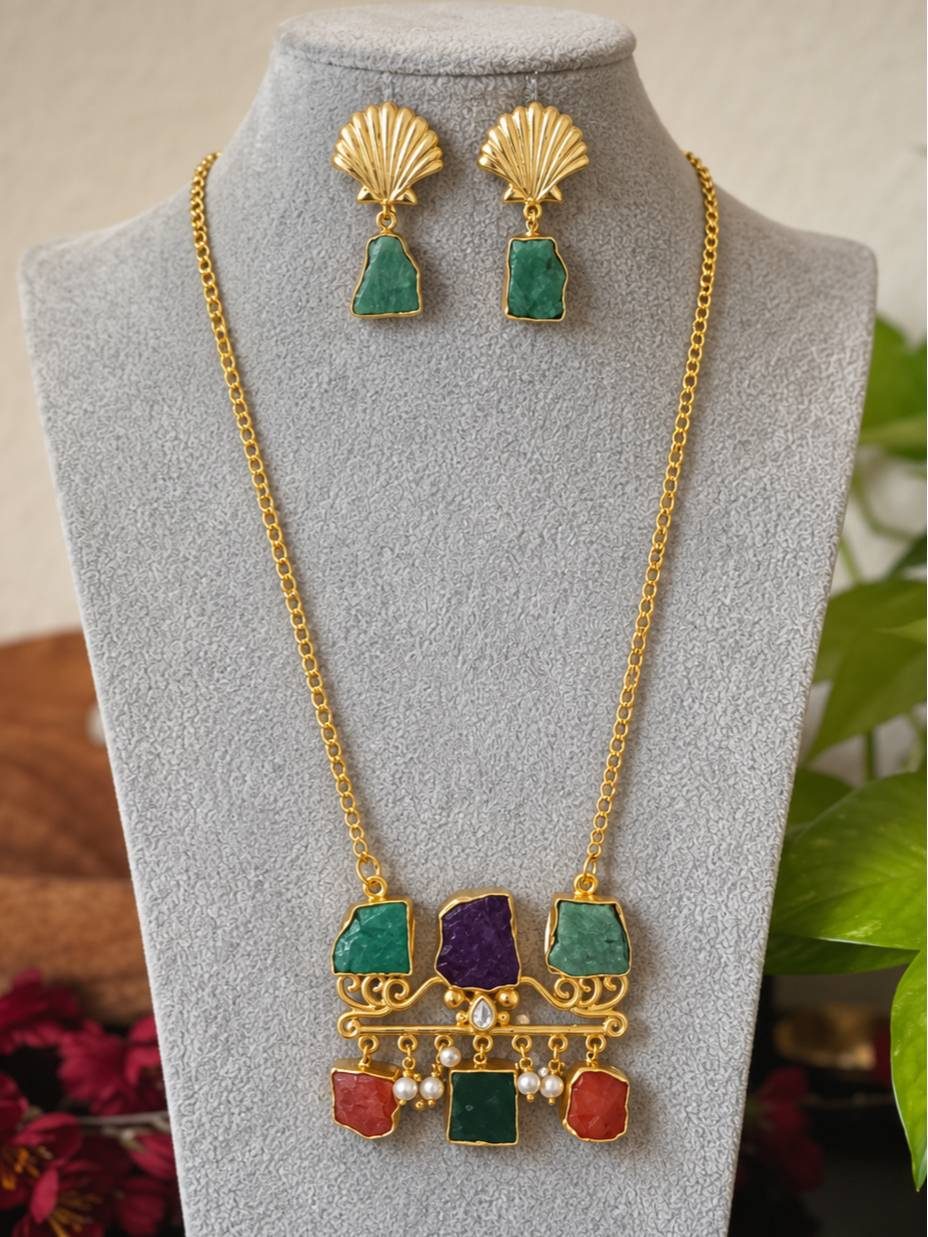 Gold-plated multicolour stone pendant necklace and shell earring set displayed on grey jewellery bust