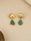 Close-up of gold seashell stud earrings with rough freeform green amazonite drops on a cream background