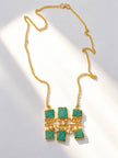 Flat lay of gold-plated amazonite pendant necklace with scrollwork and pearl drops on a white surface