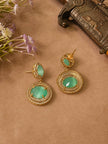 Close-up of gold-plated green stone circular drop earrings with CZ border on beige background