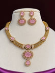 Gold-plated pink stone choker necklace and drop earring set displayed on a jewellery bust