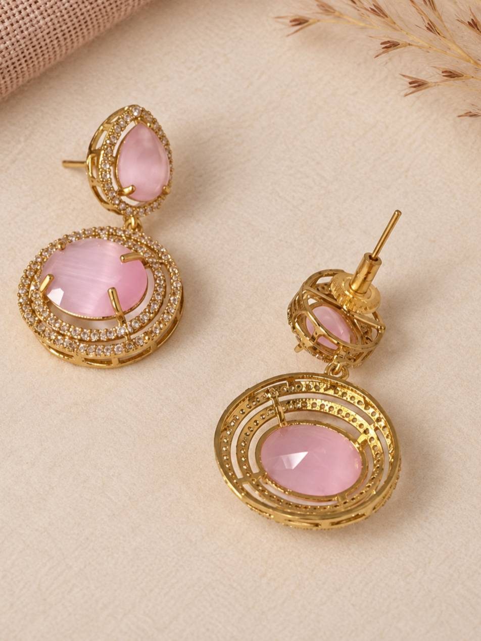Close-up of gold-plated pink cabochon drop earrings with CZ halo detailing, showing front and back