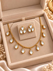 Gold-plated kundan drop necklace and stud earrings displayed inside an open beige velvet jewellery box