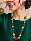 Woman wearing gold-plated kundan mala necklace and matching earrings over a green kurta