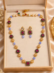 Gold-plated kundan mala necklace set with drop earrings displayed inside a cream gift box