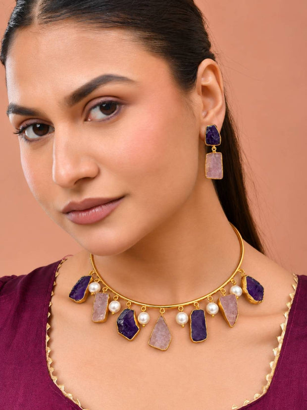 Woman wearing gold-plated raw stone choker and matching drop earrings with a maroon kurta, front-facing portrait