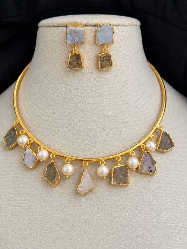 Gold-plated choker necklace with labradorite stones and faux pearls displayed on a cream jewellery bust with matching drop earrings