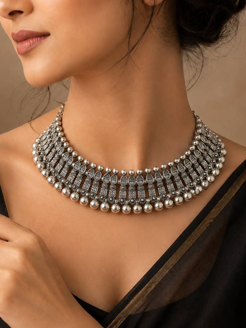 Woman wearing oxidised silver choker necklace with a black saree, showcasing full collar fit at the neckline