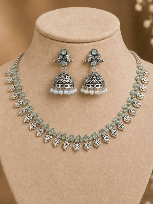 Oxidised silver leaf choker necklace and jhumka earring set displayed on a jewellery bust