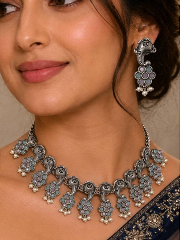 Woman wearing oxidised silver Ganesha choker necklace and earrings with a navy embroidered saree