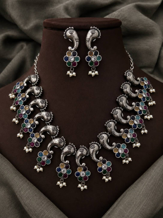 Oxidised silver Ganesha choker necklace set displayed on a dark brown jewellery bust with matching stud earrings