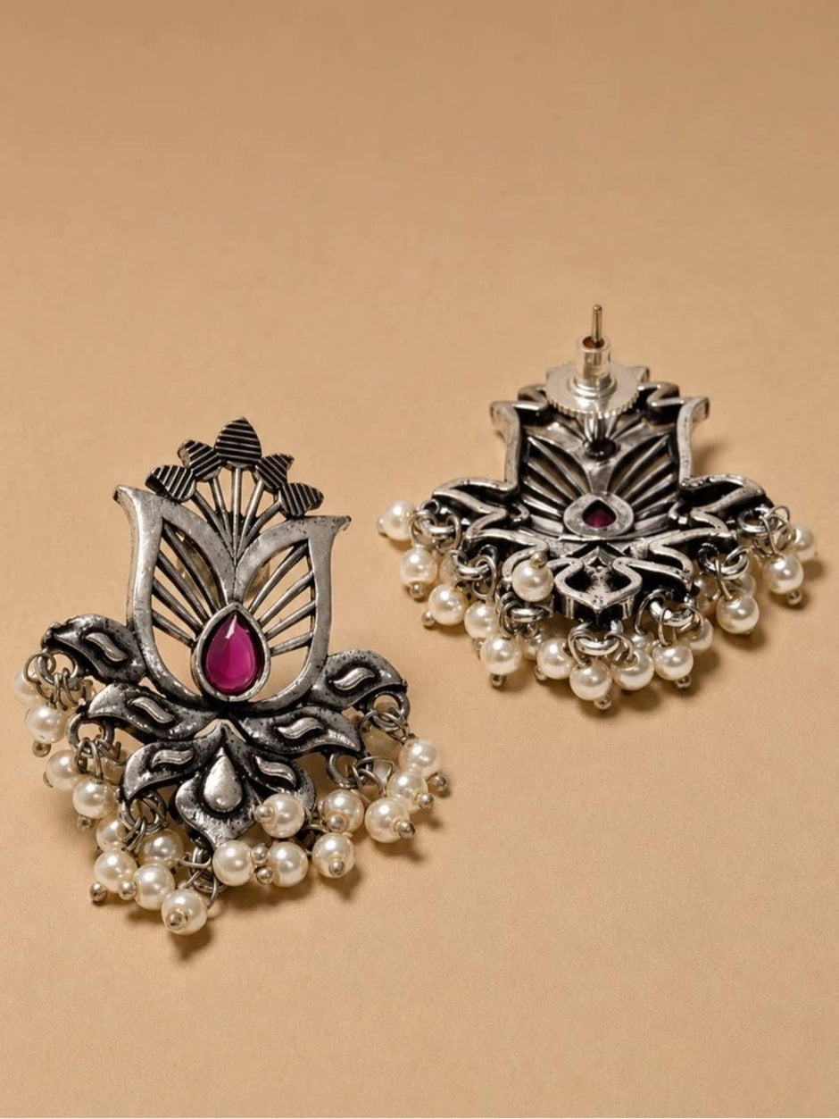 Front and reverse view of oxidised silver lotus studs showing pearl drops and push-back stud post on beige background