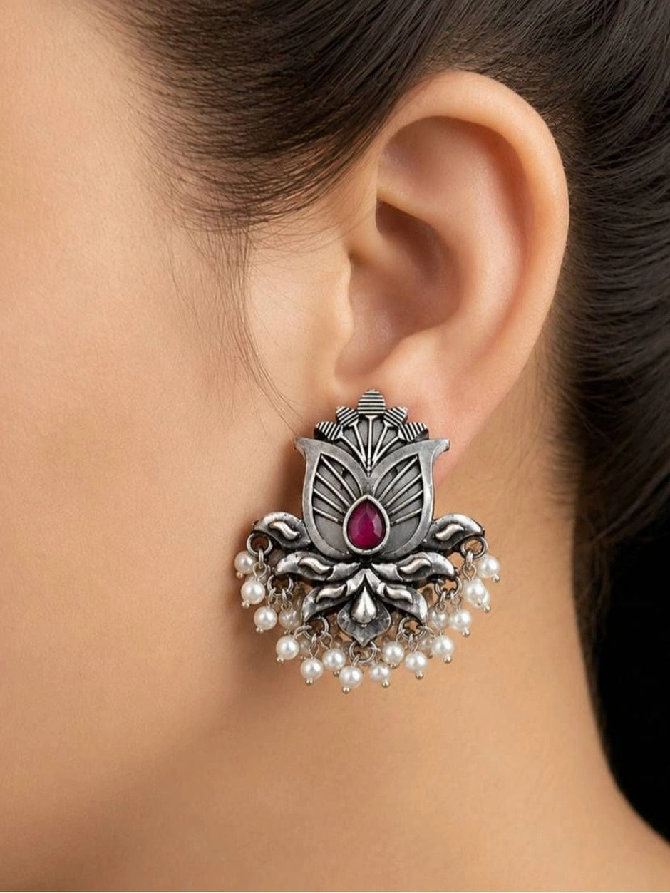 Oxidised silver lotus stud earring worn on a woman's ear showing size and drape of pearl drops against her jawline