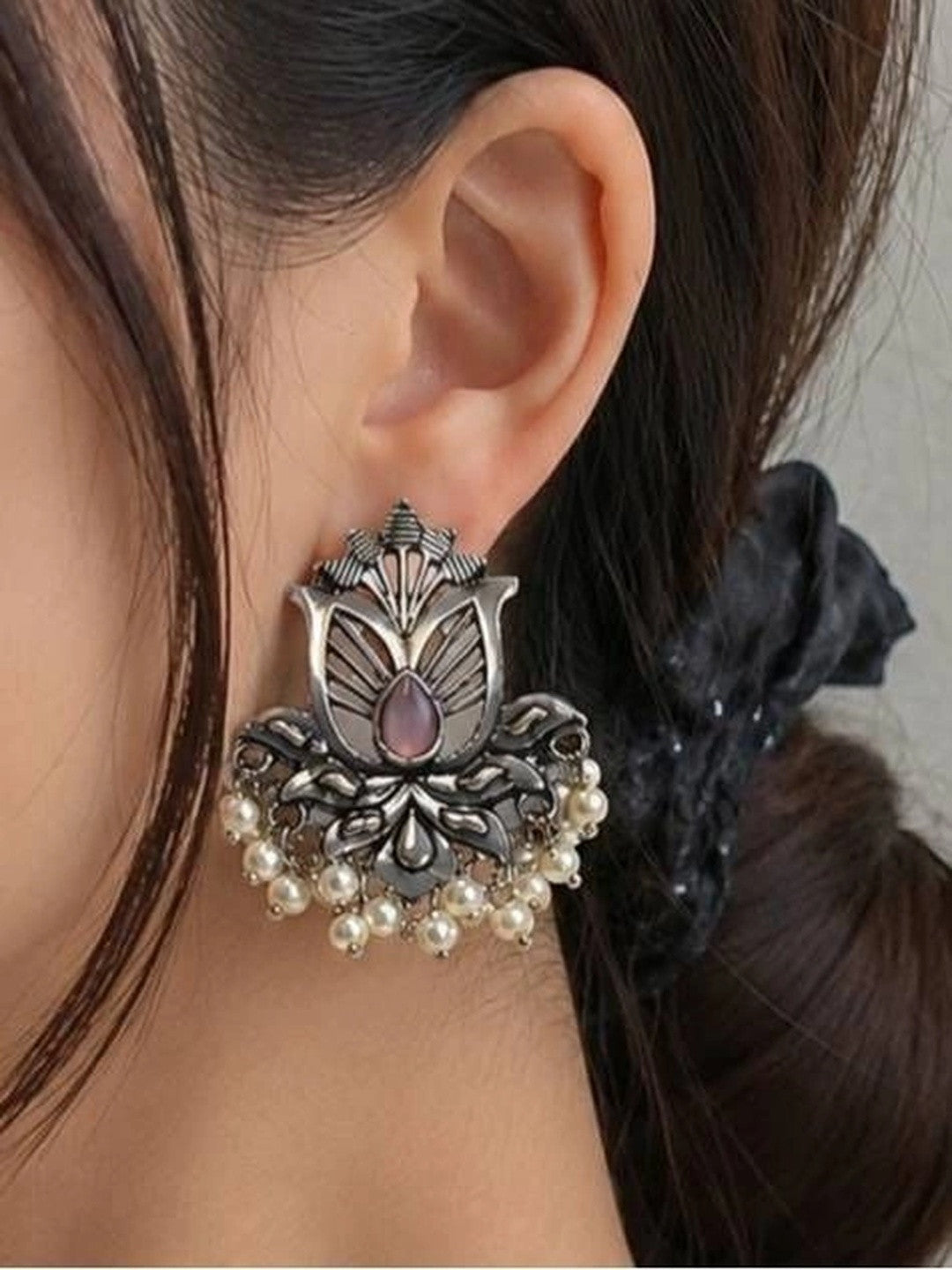 Oxidised silver lotus stud earring worn on womans ear showing scale and drape of pearl drops