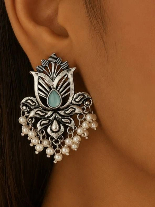 Oxidised silver lotus stud earring with aqua stone and pearl drops worn on ear