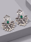 Pair of oxidised silver lotus stud earrings with green teardrop stone and ivory pearl drops, front view on grey surface
