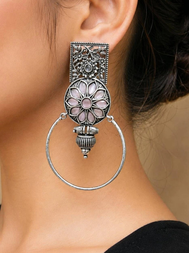 Oxidised silver floral hoop earring worn on a woman's ear showing full length and scale